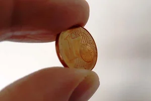 2 Finger halten einen Cent