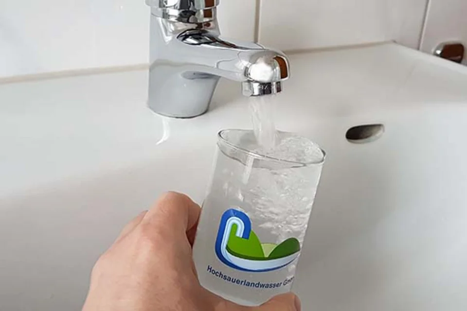Ein Glas Wasser unter einem Wasserkrahn